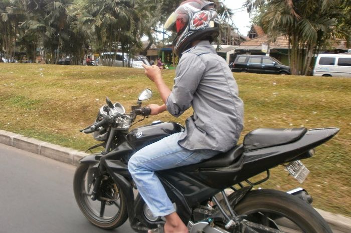 menggunakan HP saat bermotor