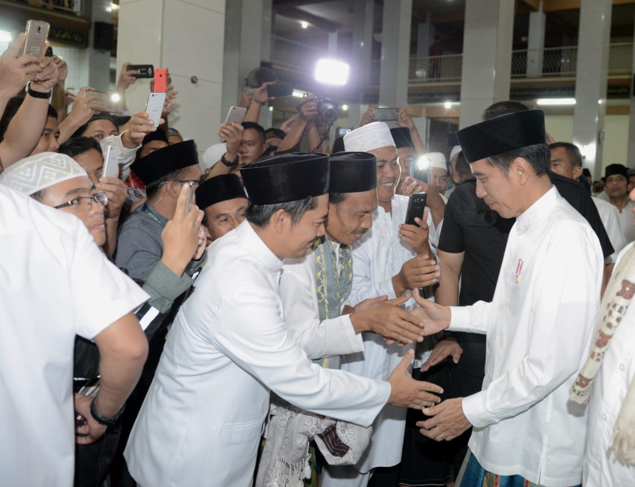 Masyarakat sekitar tampak antusias menyambut kehadiran Presiden Jokowi. 