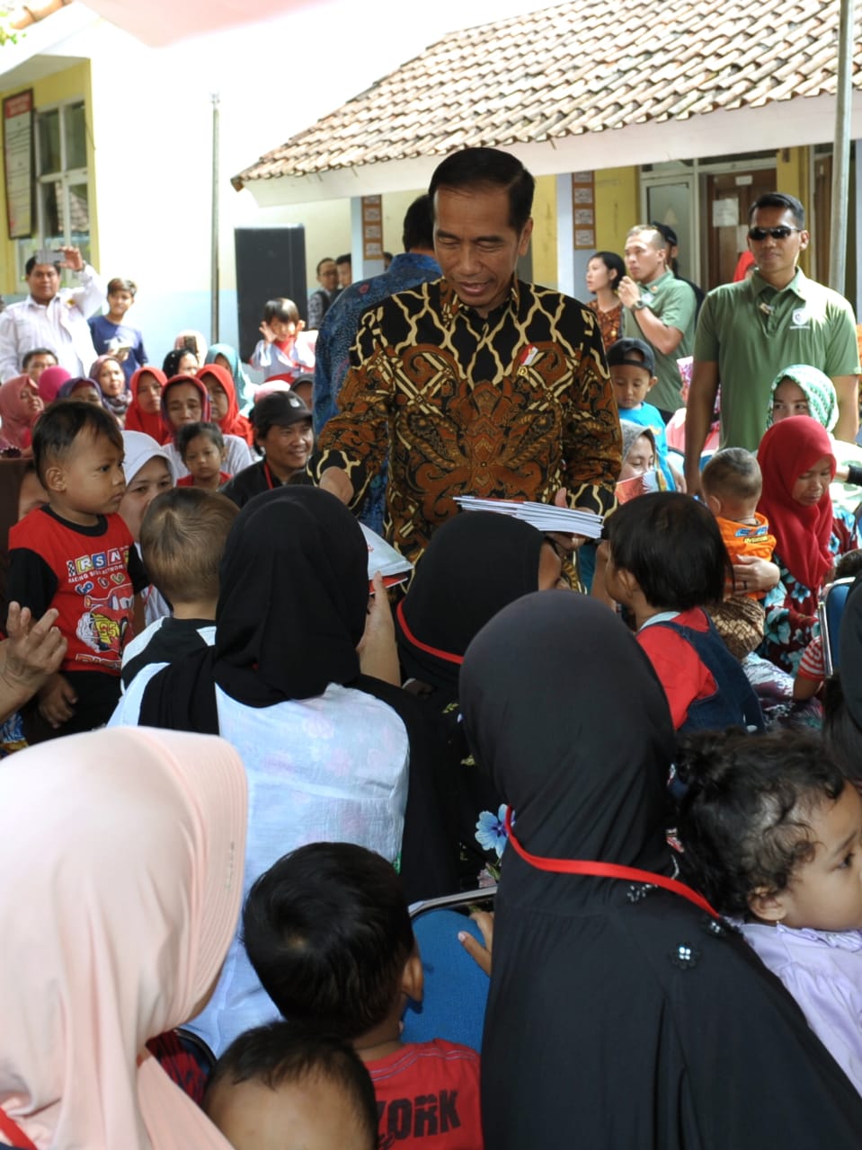 Presiden Joko Widodo membagikan buku tulis kepada anak-anak saat blusukan ke Desa Tangkil, Kecamatan Caringin, Kabupaten Bogor, Rabu (4/7) 2018.