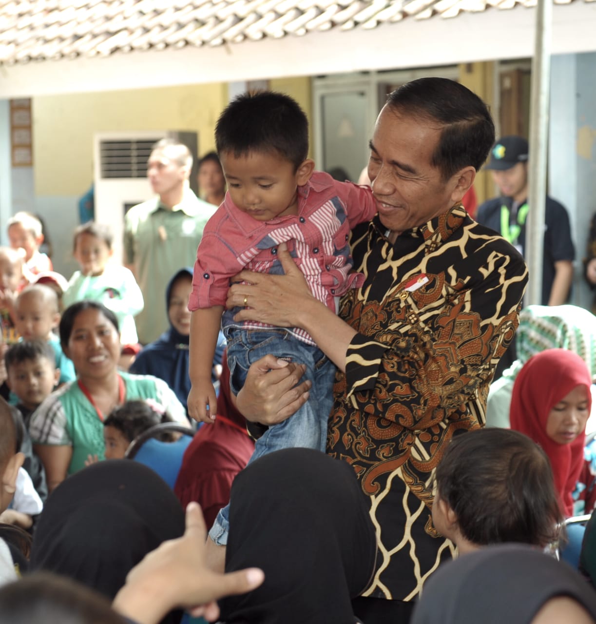 Presiden Joko Widodo menggendong seorang anak saat blusukan ke Desa Tangkil, Kecamatan Caringin, Kabupaten Bogor, Rabu (4/7) 2018. Ia mendorong untuk menaruh perhatian setinggi-tingginya unuk para generasi penerus bangsa ini.  